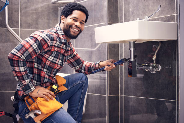 Portrait, man and plumber with smile, maintenance and installation with home repairs. Face, Nigerian male employee or worker with tools, fixing pipes and sink with handyman, contractor and renovation